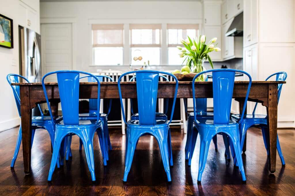Family dining... Blue chairs with a retro design contrasted as they surround a more primitive table.